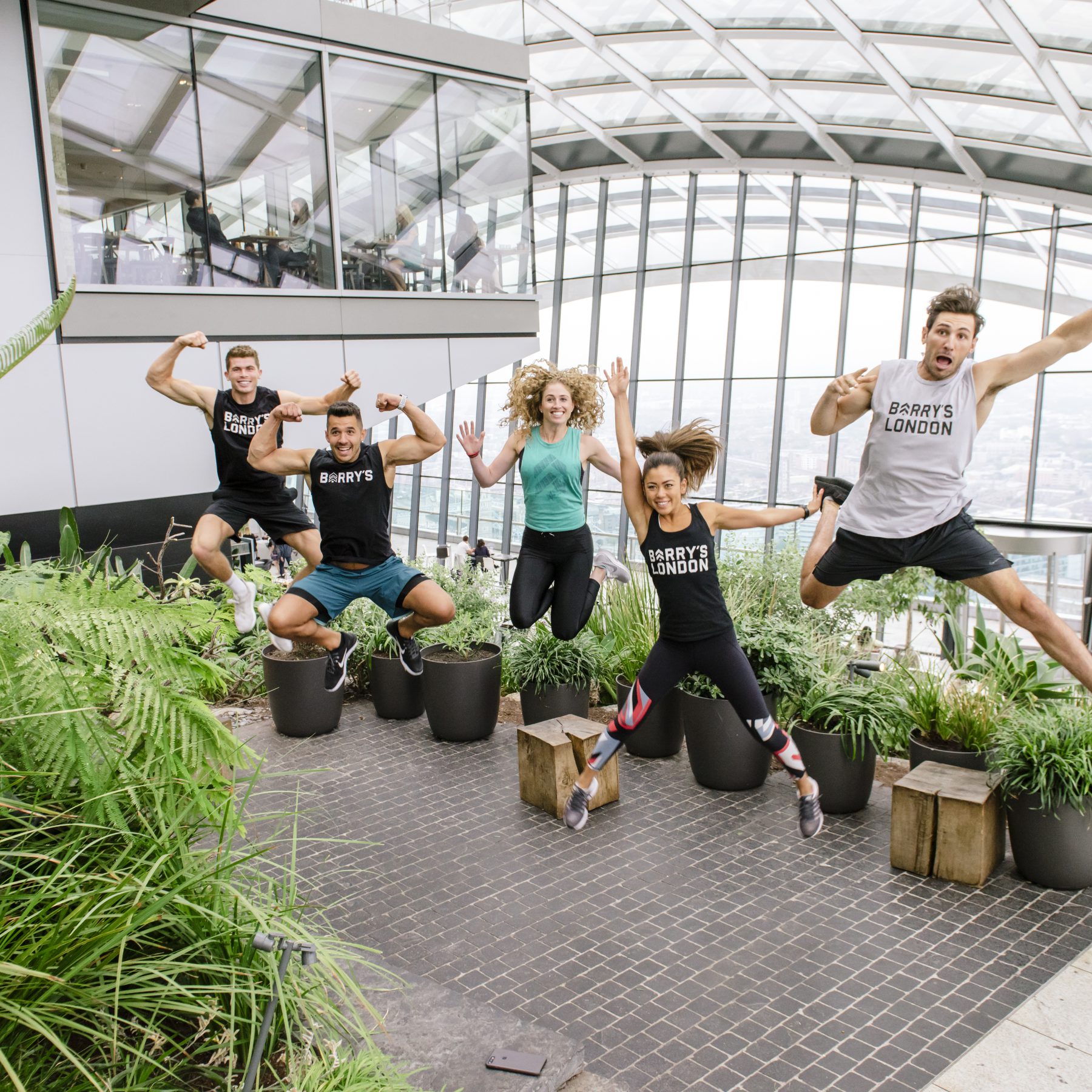 Five people jumping in the air inside Sky Garden cheering